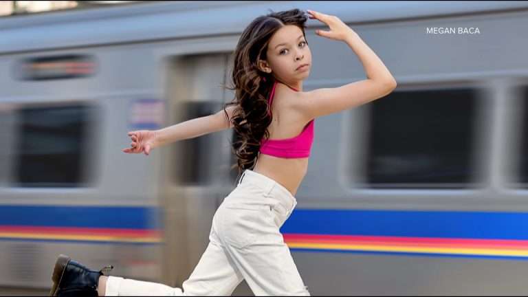 a little girl in the pink top and white trousers